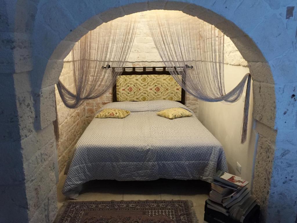 阿尔贝罗贝洛安蒂卡飞雷利亚度假屋的一间卧室,配有拱形床