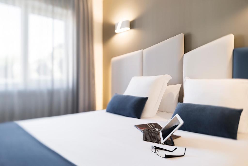 比韦罗博阿维斯塔美食酒店的酒店客房,配有一张带笔记本电脑的床
