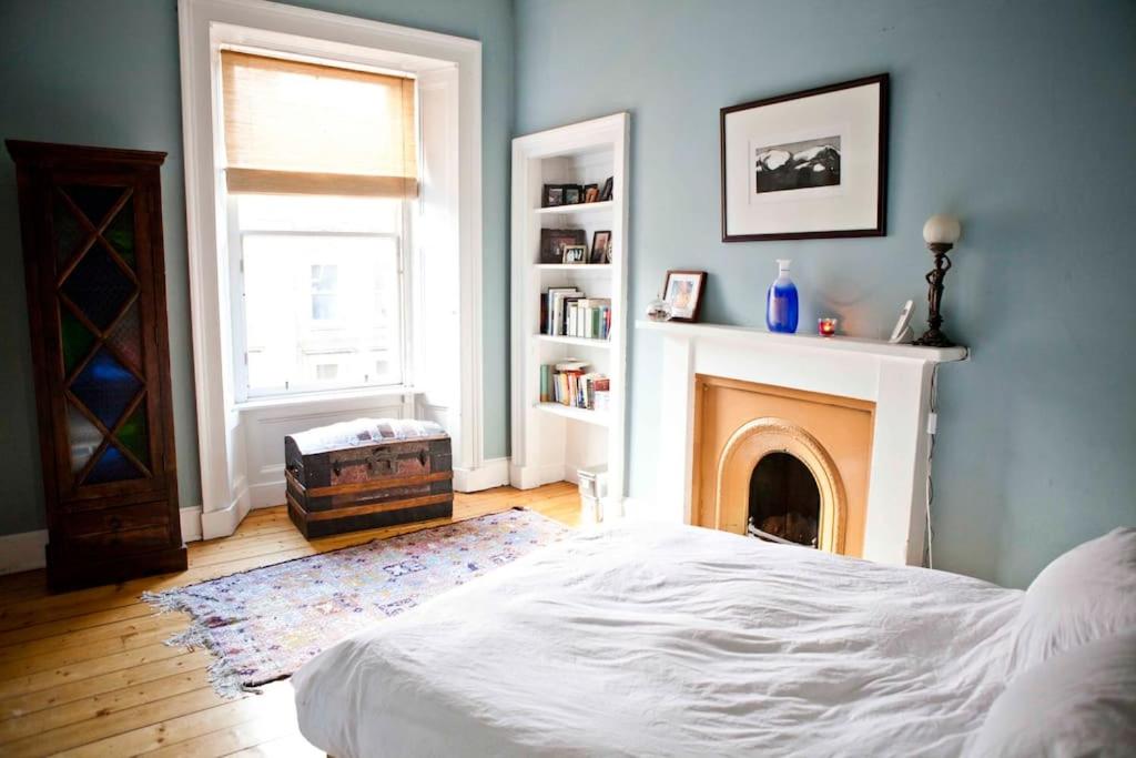 爱丁堡美食家文员公寓 的卧室配有白色的床和壁炉
