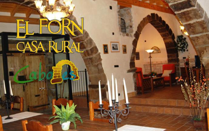 卡瓦内斯Casa Rural Forn del Sitjar的一间设有吊灯和一张带蜡烛的桌子的餐厅的房间
