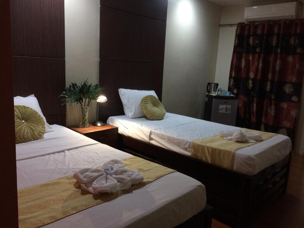 奥隆阿波马尼亚娜酒店 的两张位于酒店客房的床,配有毛巾