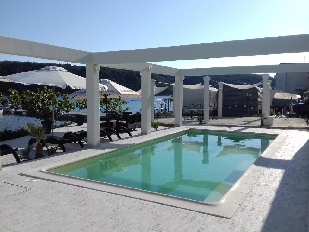 坎普尔Guesthouse Raffaello的露台的游泳池,带遮阳伞