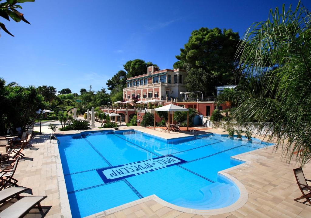 奥斯图尼诺维切托公园度假酒店的一个带椅子的游泳池和一个背景建筑
