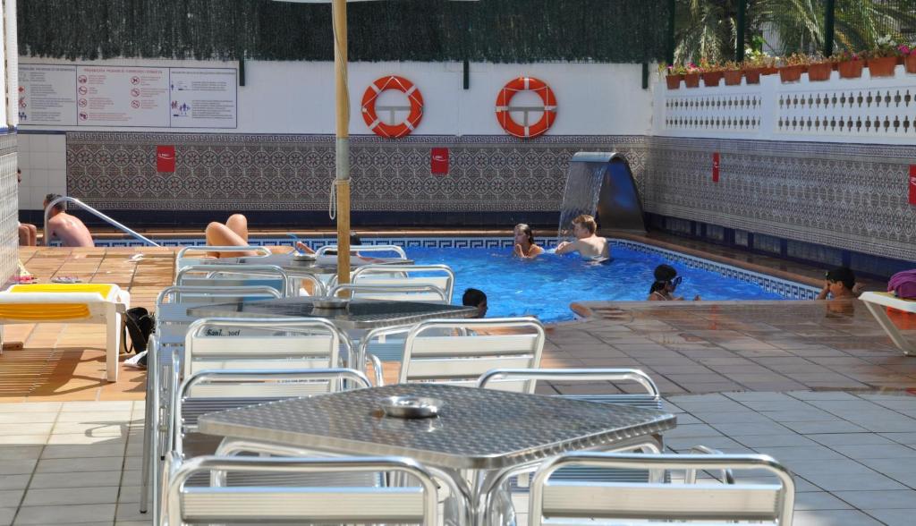 卡里拉萨法里公寓式酒店的一个带桌椅的游泳池,水中有人