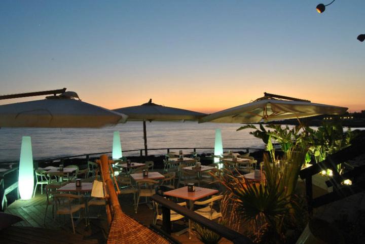 皮佐Villino Sole的海滩上设有桌子和遮阳伞的餐厅