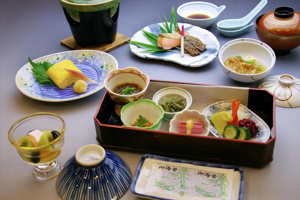 京都金柏来酒店的一张桌子,上面放着一盒食物和盘子