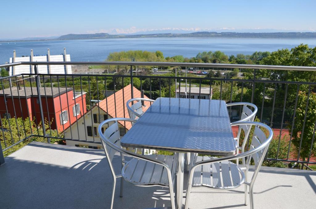 纳沙泰尔萨尔斯33号度假公寓的阳台配有桌椅,享有水景