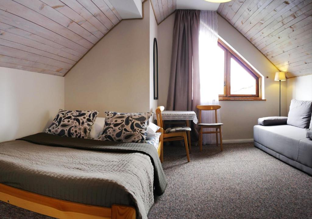 弗瓦迪斯瓦沃沃Anka的一间卧室配有一张床、一张沙发和一个窗口