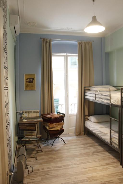 热那亚Victoria House Hostel的一间卧室配有双层床和书桌