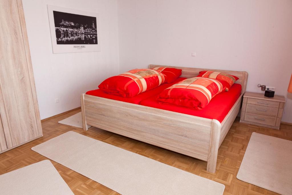 Plankstadt科尔公寓的一张床上,床上有红色的床单和红色的枕头