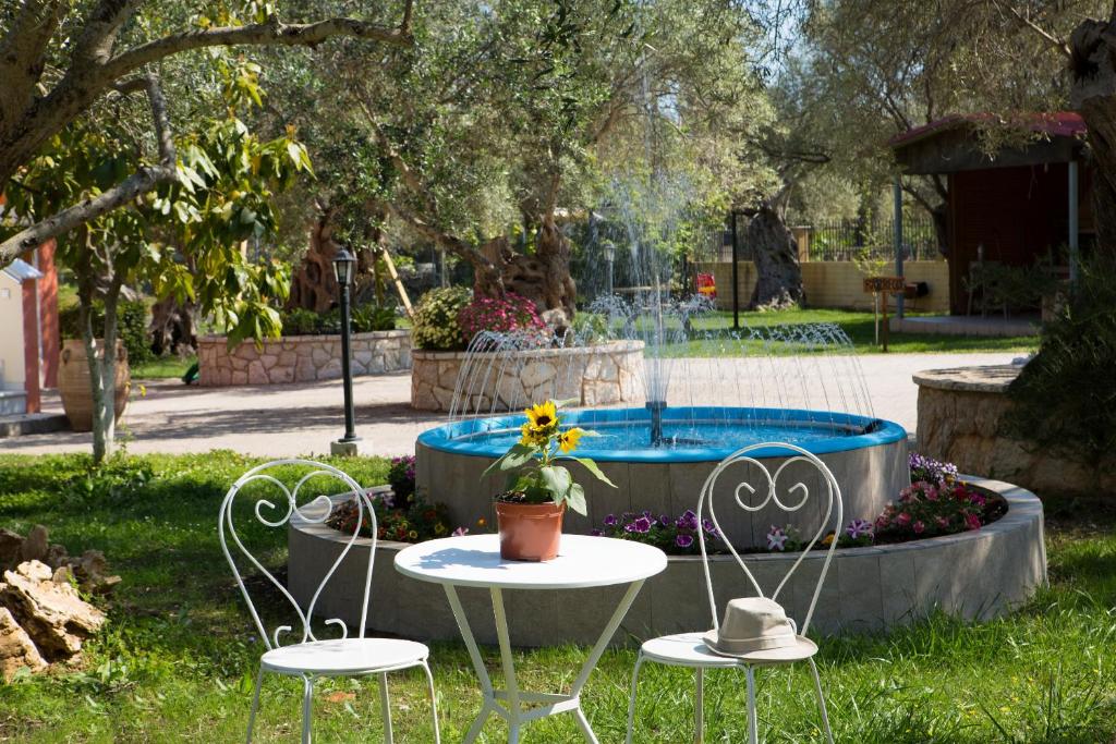 雷夫卡达镇Santa Maria Luxury Apartments的公园内两把桌子和椅子,设有游泳池