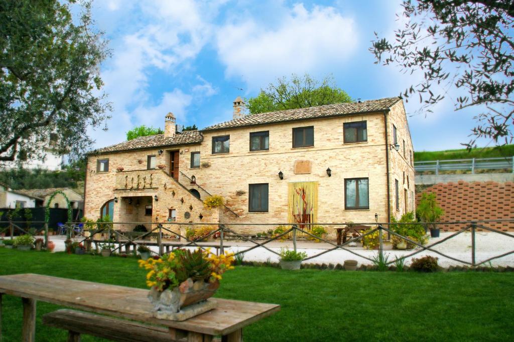 费尔莫Il Vecchio Pioppo的一座大石头房子,在院子里设有长凳