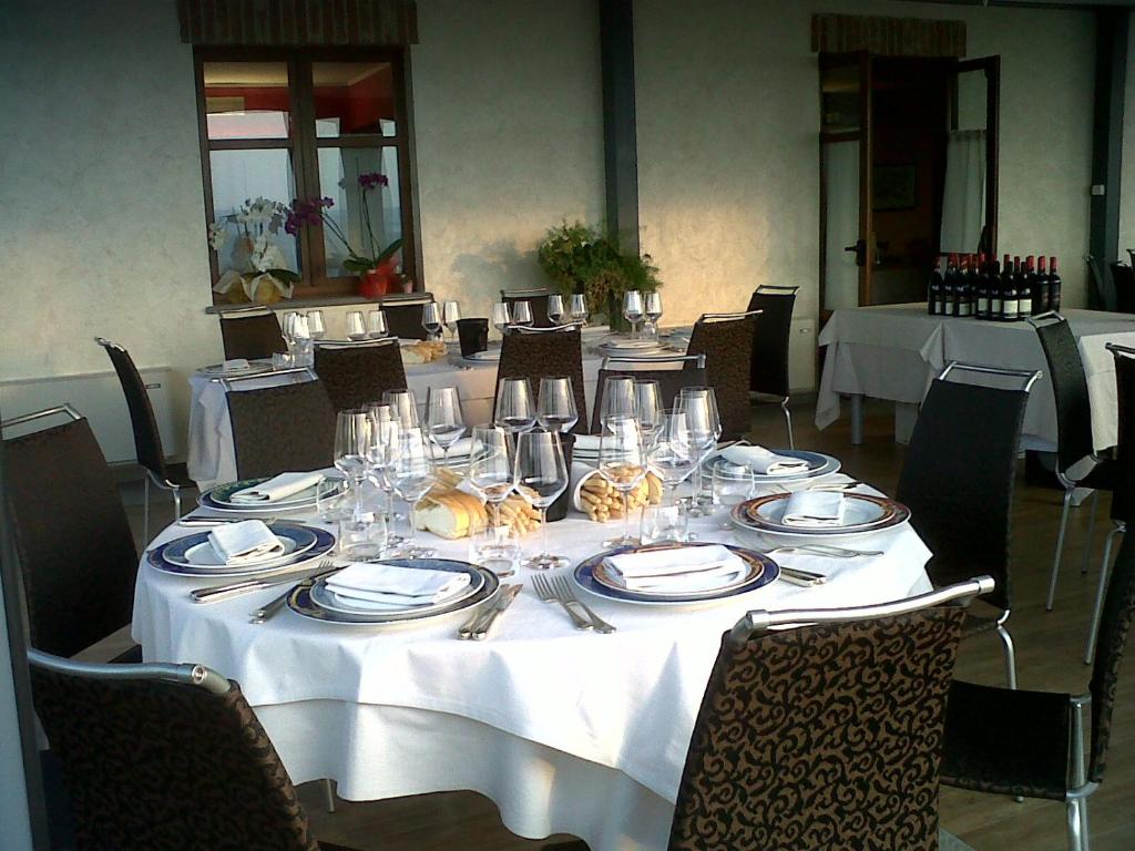 塞拉伦加达尔巴La rosa dei vini的一张桌子,上面有白色的桌布,盘子和银器