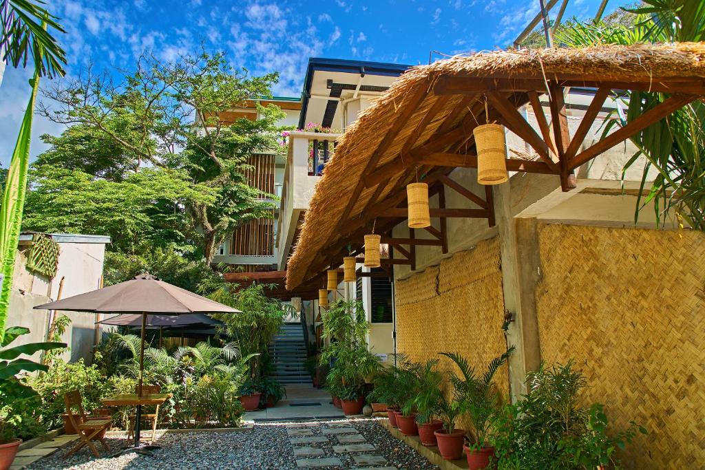 爱妮岛Amakan - El Nido Palawan的一座带遮阳伞和庭院的建筑