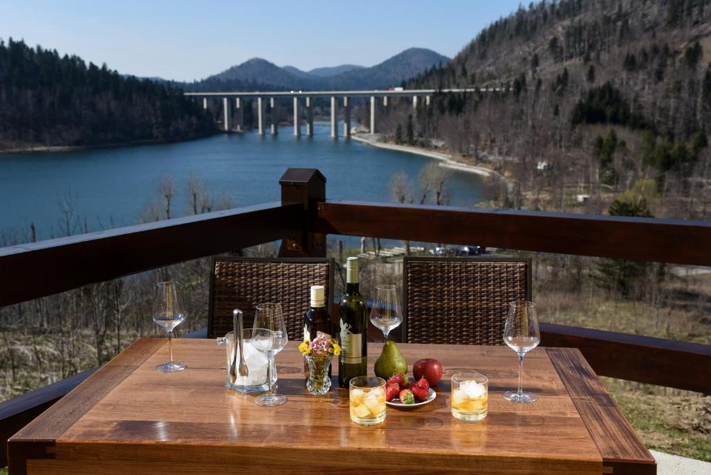 弗济内Villa MOYA 1的一张带酒杯的木桌,享有桥梁的景色