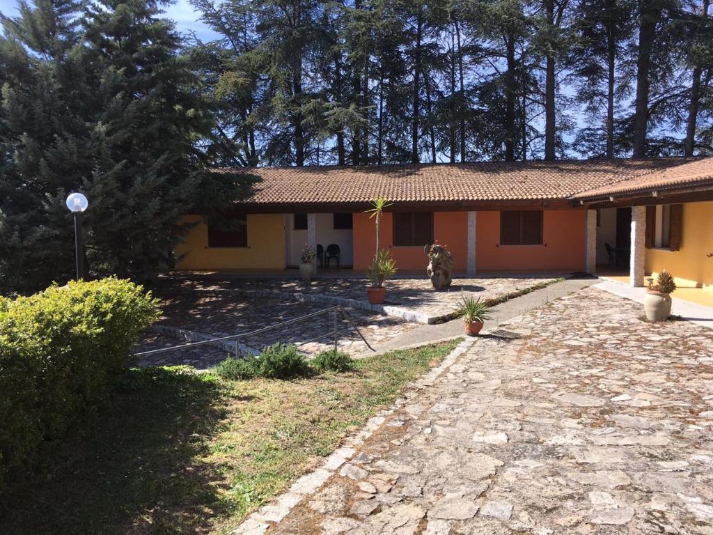 OraniAgriturismo Usurtala的一座黄色的小房子,有石头车道