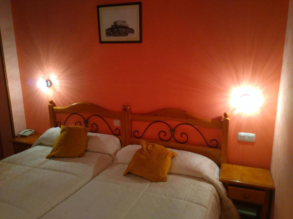 塞哥维亚圣米格尔酒店的卧室配有一张带两盏灯的墙壁床。