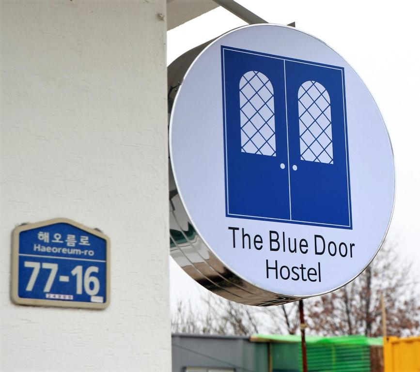 束草市Blue Door Hostel Guesthouse的建筑物旁蓝色门医院的标志