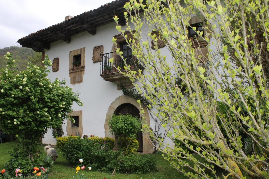 科斯加亚Casona de Treviño的带阳台和鲜花的大型白色房屋