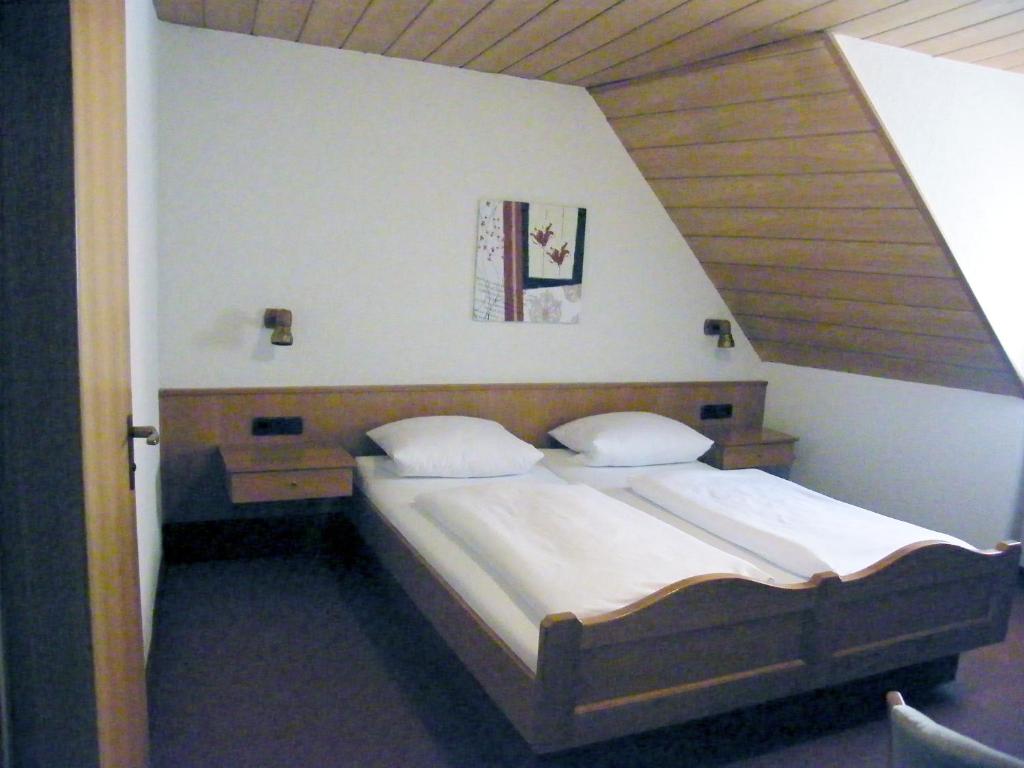 罗滕堡霍夫曼施默泽膳食公寓酒店的一间卧室配有一张大床和木制床头板