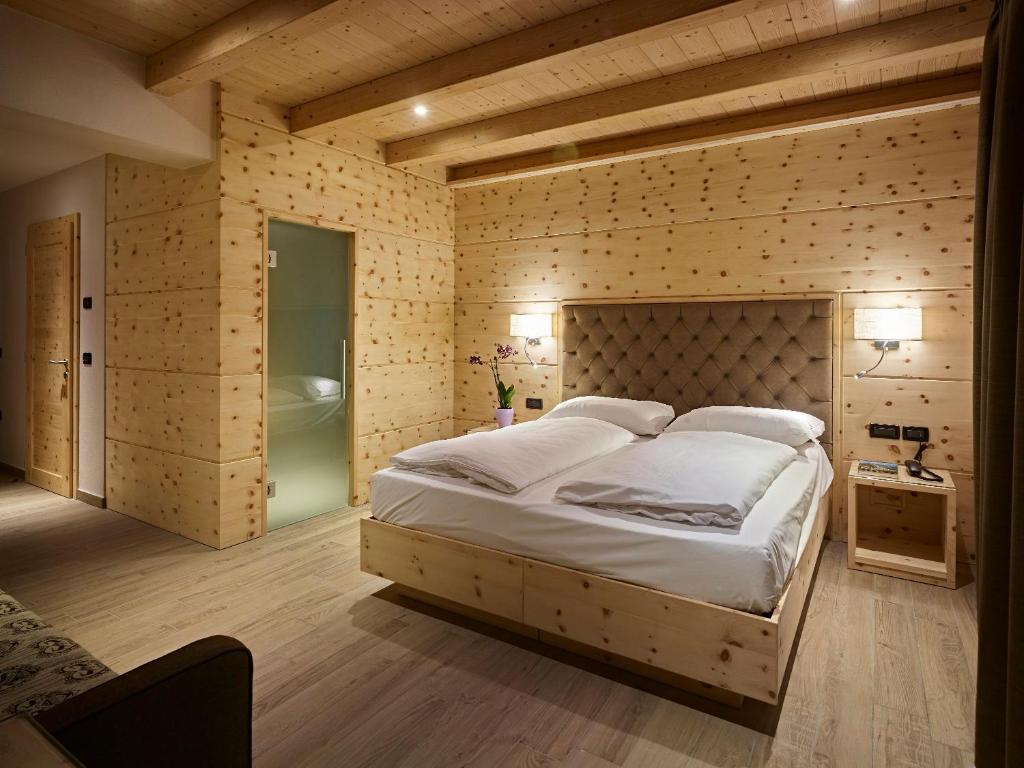 莱德罗Hotel Garni Minigolf my Ledro的一间卧室设有一张大床和一个浴缸