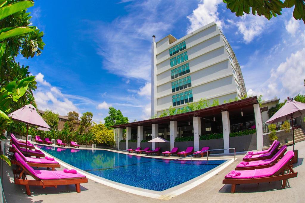 莱卡邦Amaranth Suvarnabhumi Hotel的拥有紫色躺椅和游泳池的酒店