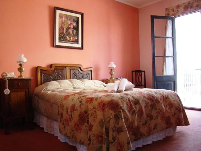 科洛尼亚-德尔萨克拉门托贝尔特兰酒店的一间卧室配有一张带橙色墙壁的大床