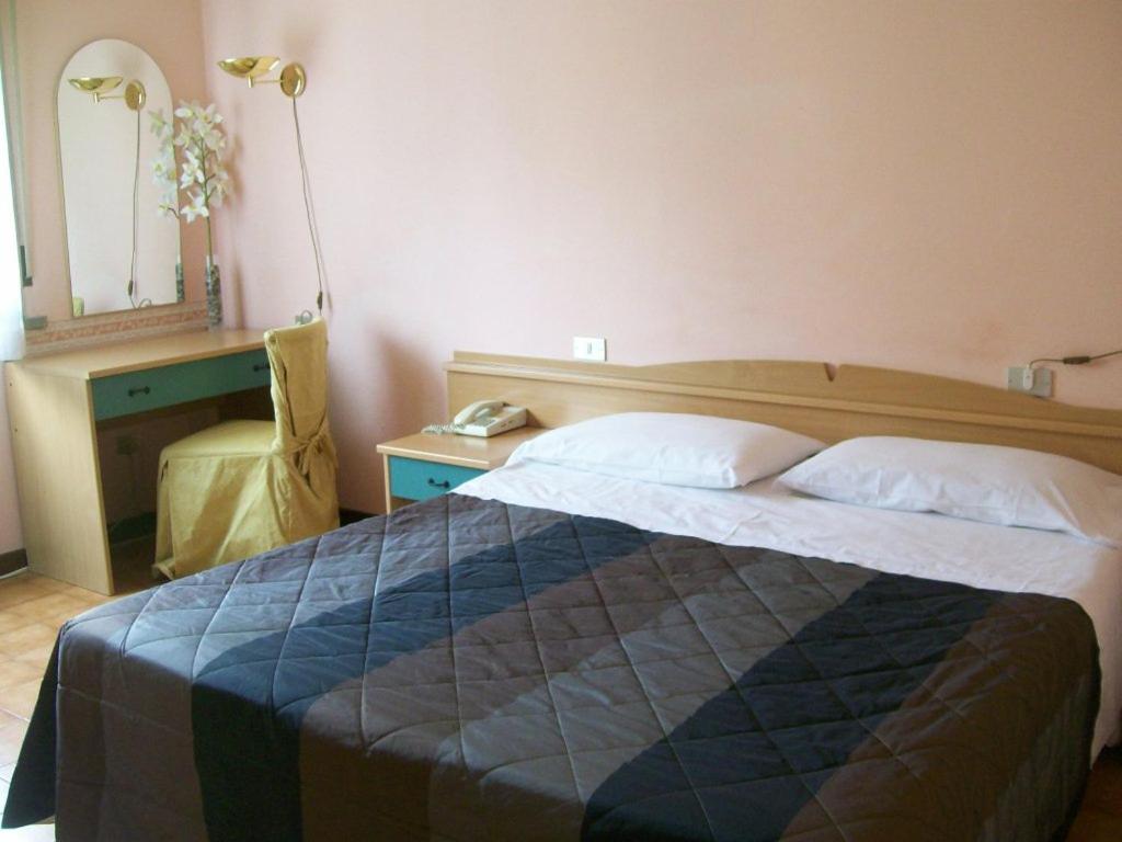 雷焦艾米利亚拉罗斯塔酒店的一间卧室配有一张床、一张桌子和一盏灯