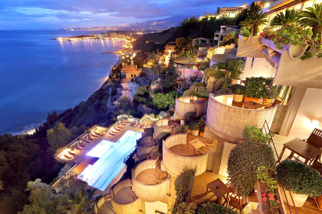陶尔米纳欧洲之星蒙特道罗酒店 的享有带游泳池和海洋的度假村的空中景致