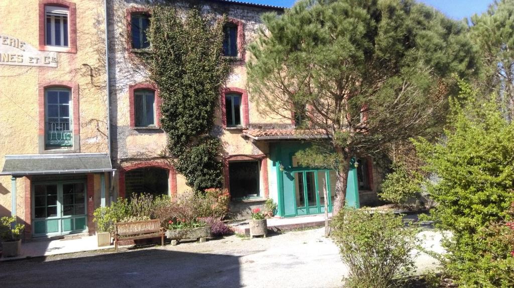 索雷兹拉贝磨坊酒店的一座古老的砖砌建筑,拥有绿门和树木