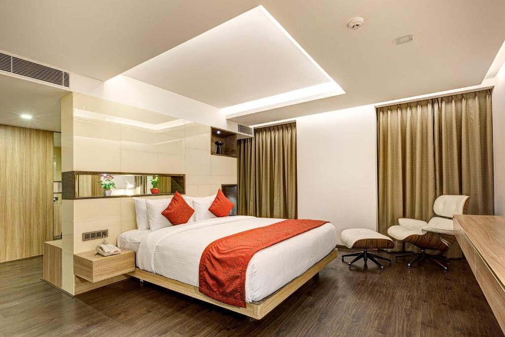 班加罗尔Attide Hotel的配有一张床和一张书桌的酒店客房