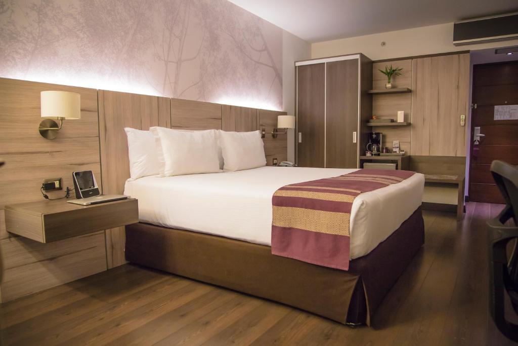 利马阿酷酒店的酒店客房设有一张大床和一张书桌。