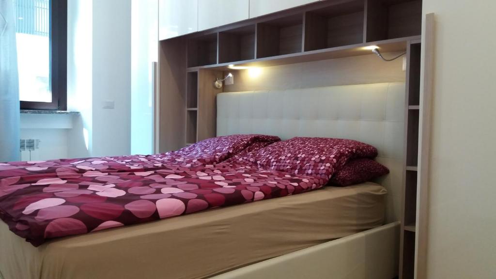 米兰尼斯拉匝罗尼生活公寓的卧室内的一张带紫色棉被的床