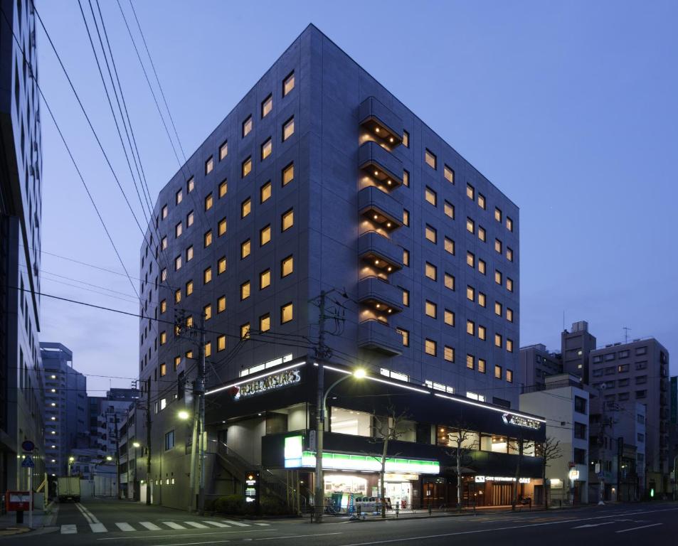 东京MYSTAYS 御茶之水（会议中心）酒店的夜幕降临的城市街道上一座高楼