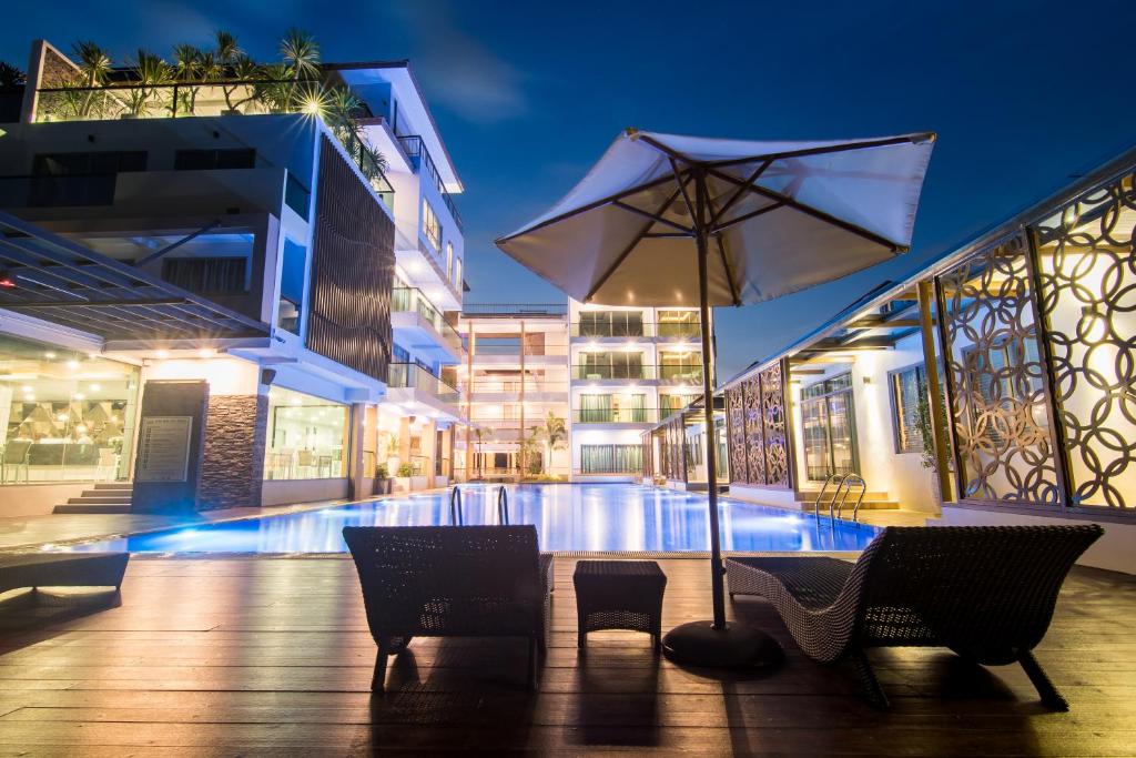 尖竹汶匹克酒店的一个带遮阳伞和椅子的庭院和一个游泳池