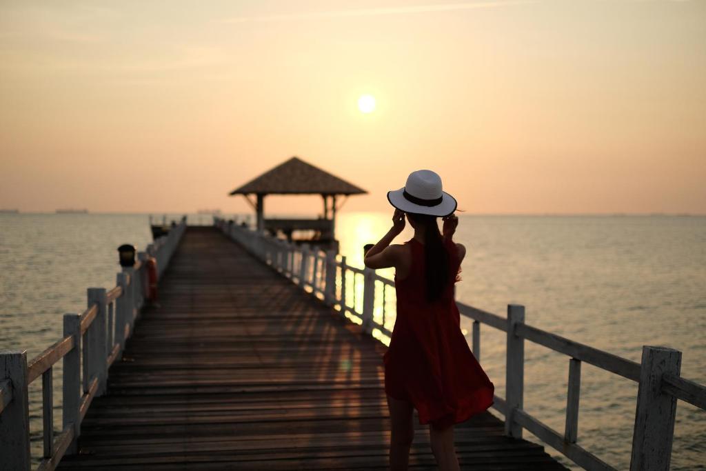 邦盛卡萨鲁纳尔棒桑别墅的站在码头上看着日落的女人