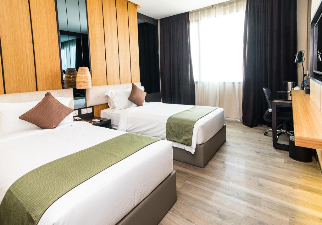 巴淡岛中心艾斯卡酒店的酒店客房配有两张床和一张书桌