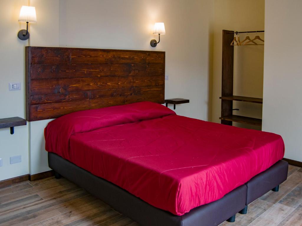 菲乌米奇诺睡觉旅行酒店的一间卧室配有一张红色大床和木制床头板