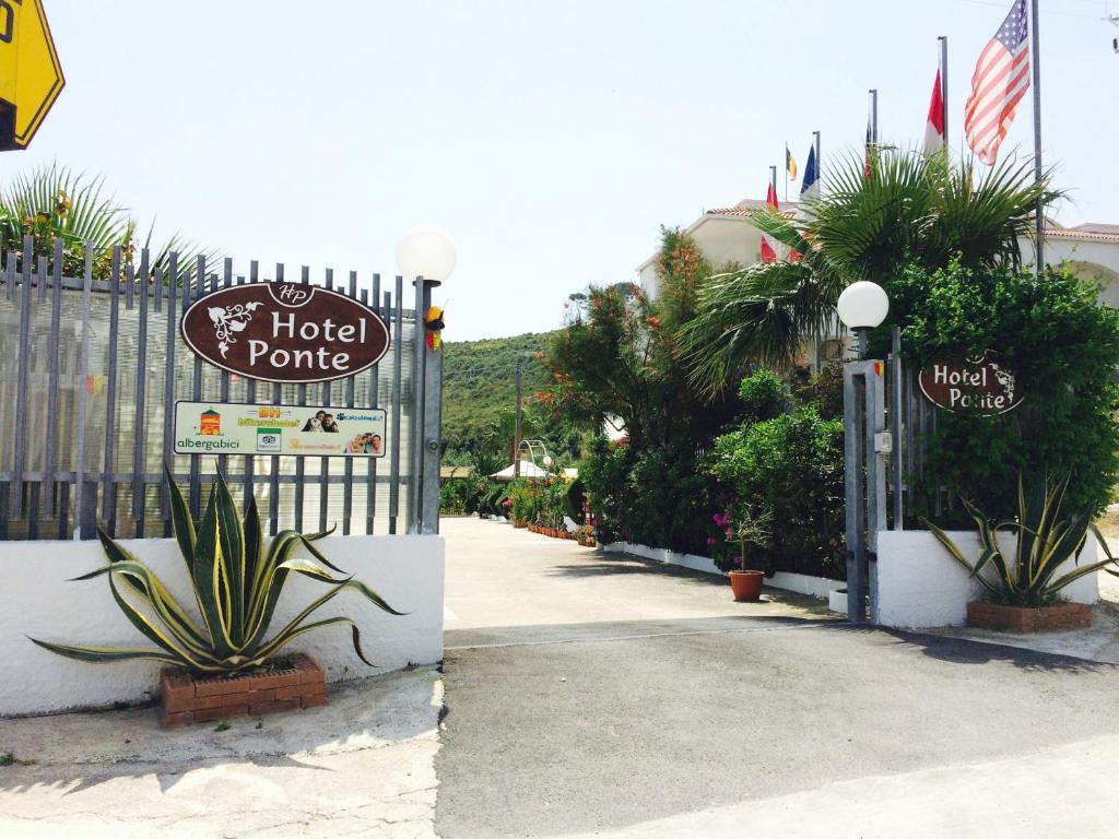 维耶斯泰Hotel Ponte的一座酒店门户标志,旁边是一座带植物的栅栏
