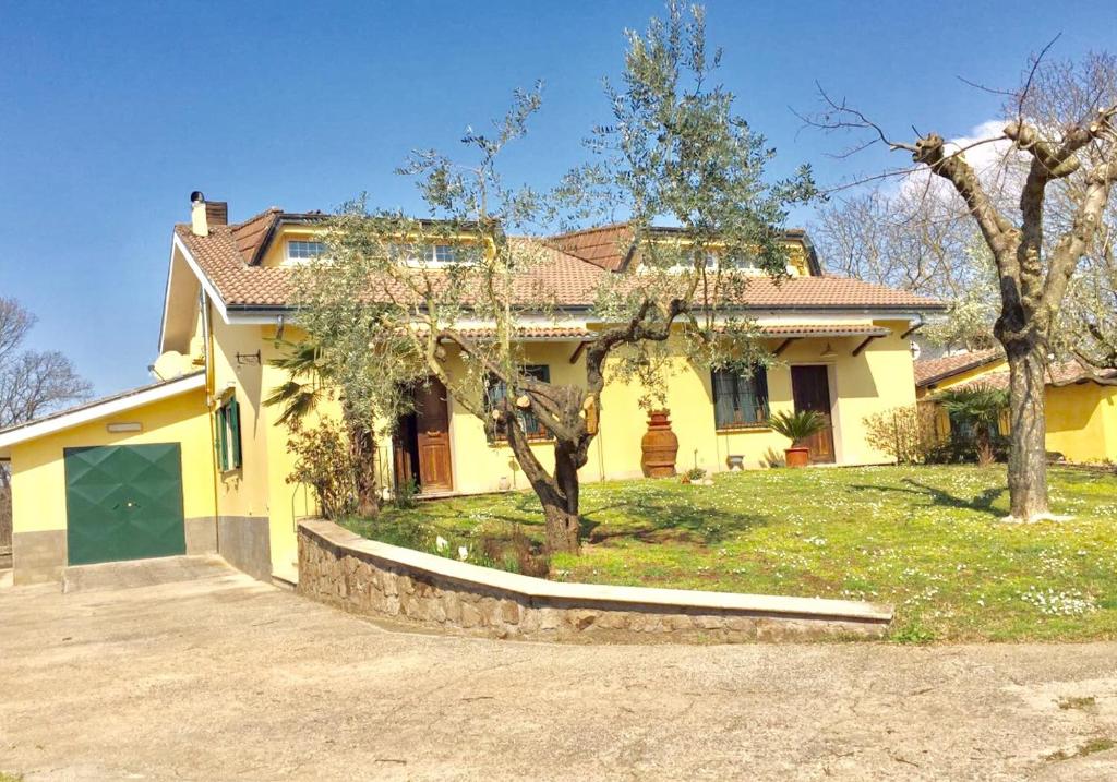 瓦尔蒙托内佩雷托住宿加早餐旅馆的前面有车道的黄色房子