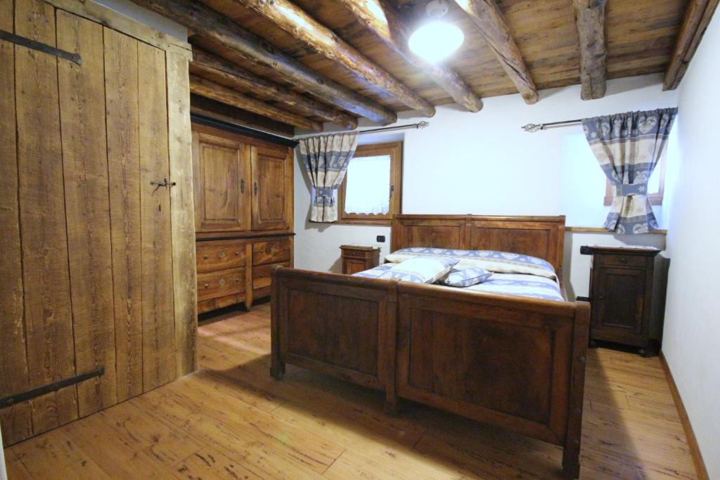 奥斯塔Vecchio Fienile的一间卧室设有床铺、木墙和木地板