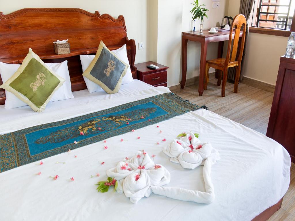 金边丹塞精品酒店的一间卧室配有带毛巾的床