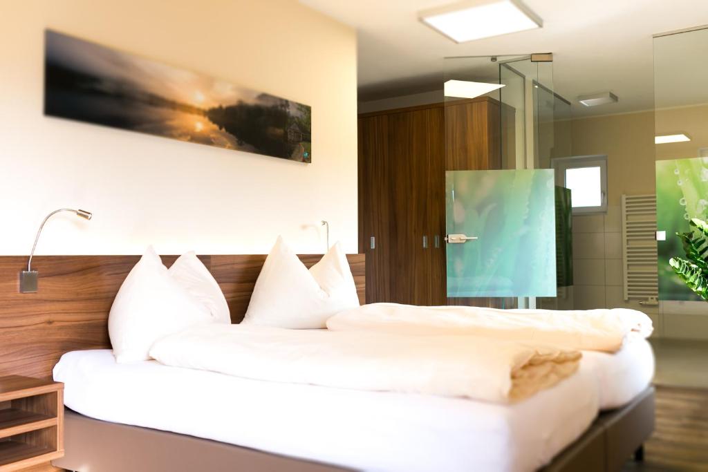 蒙德塞Hotel Aichingerwirt的卧室配有带白色枕头的大床