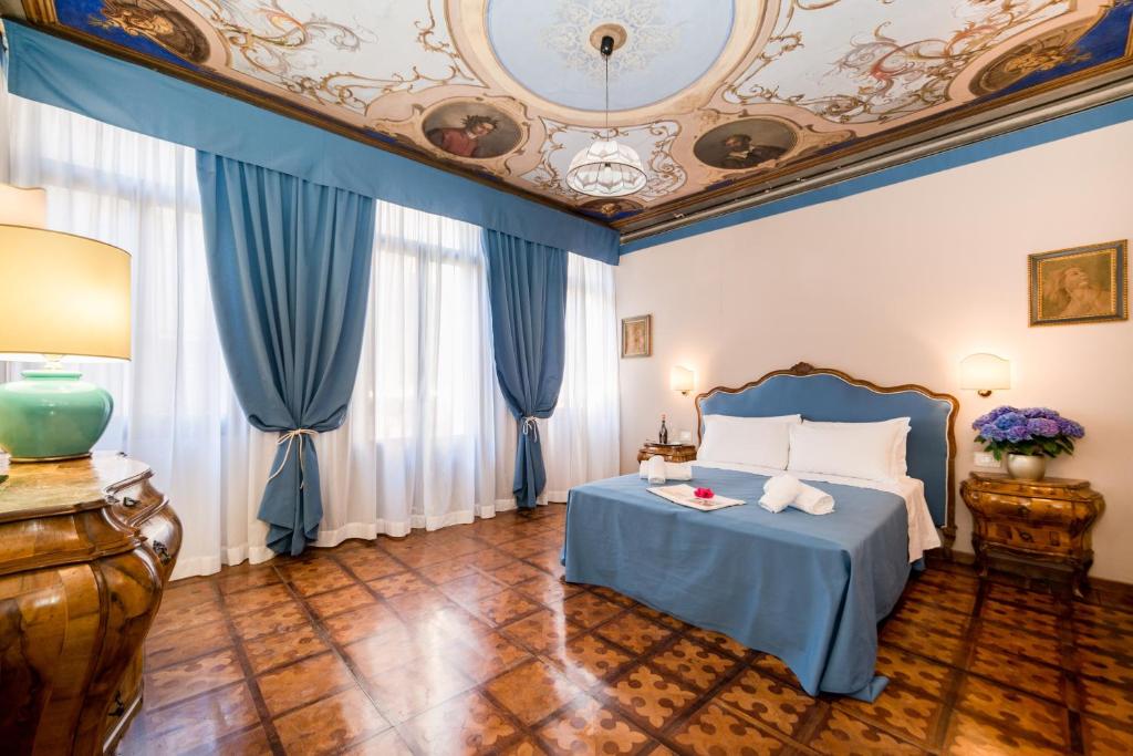 威尼斯卡拉瓦泽拉公寓的一间卧室设有蓝色的床和天花板