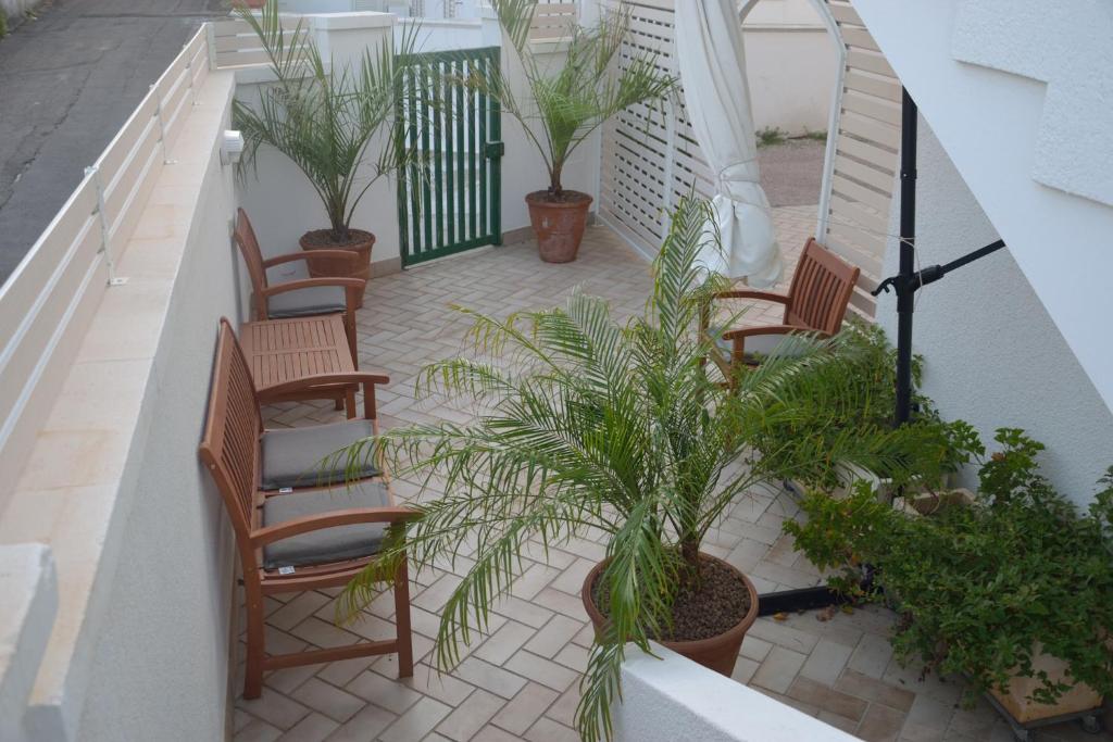 莱乌卡A casa di Elena的阳台配有椅子和盆栽植物