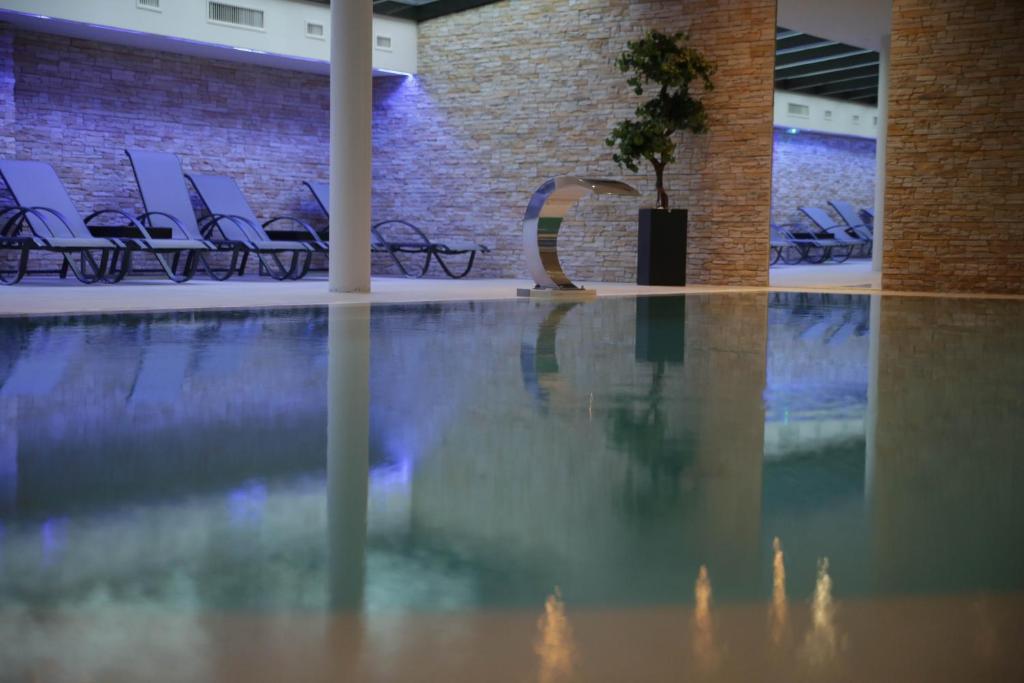 奥斯泰姆莱斯西格纳奥克斯住宿酒店的一座带椅子和一棵树的游泳池