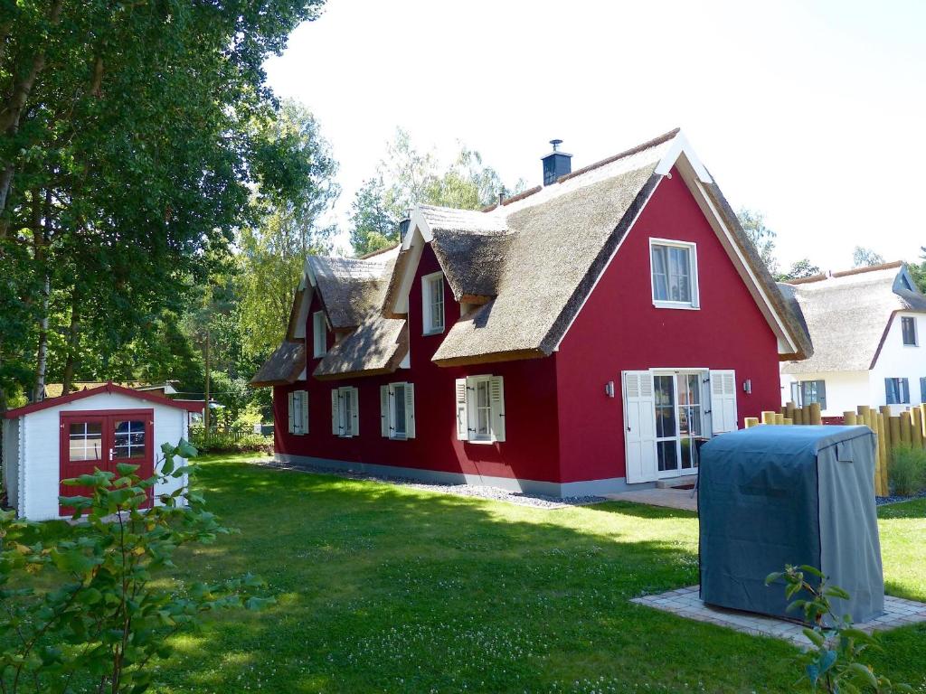 格洛韦Ferienhaus Greta的一座带草地庭院的大型红色房屋