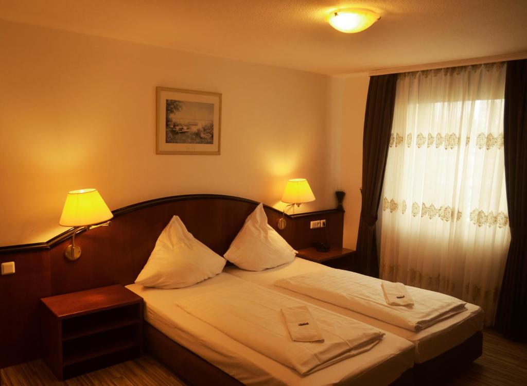 哥廷根泛海酒店的一间卧室配有一张床,上面有两条毛巾