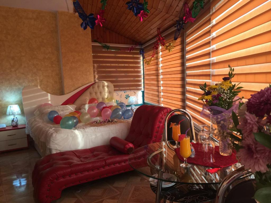 纳布卢斯Isra Hotel的一间卧室配有一张带红色沙发和玻璃桌的床