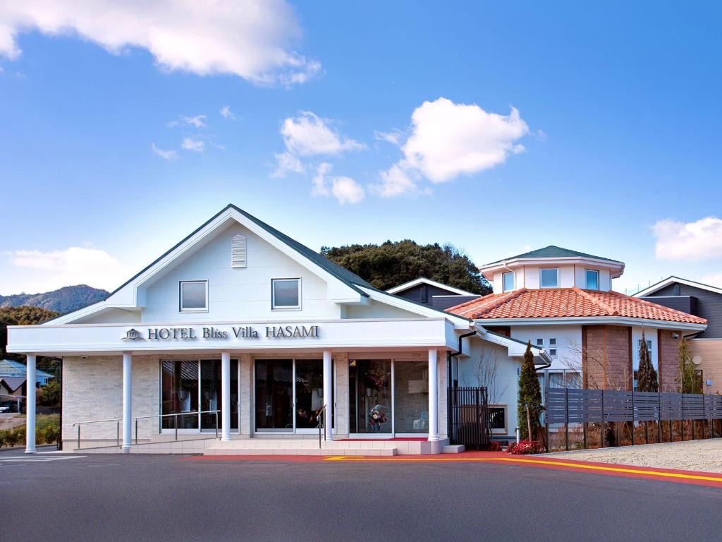 Hasami波佐见极乐别墅酒店的白色的建筑,前面有标志